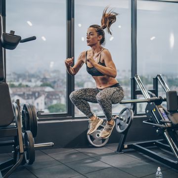 Young athletic woman exercising jumps in a health club.