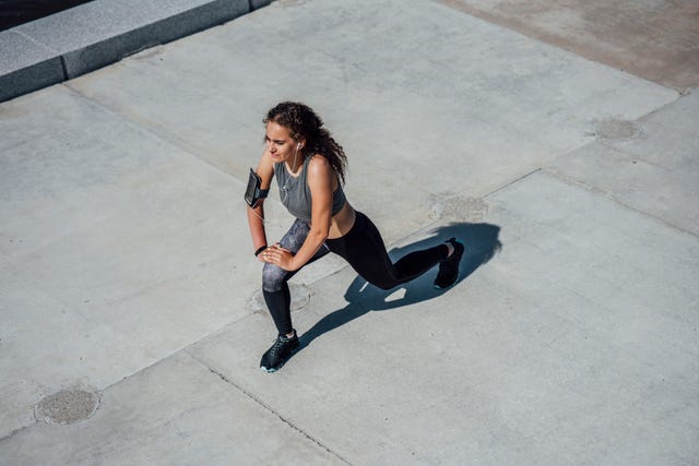 young athletic woman stretching outdoors