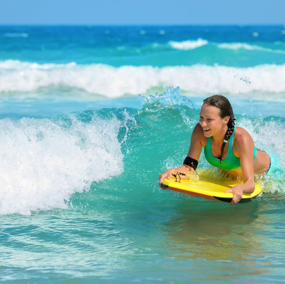 https://hips.hearstapps.com/hmg-prod/images/young-attractive-woman-bodyboards-on-surfboard-with-royalty-free-image-1687470790.jpg?crop=0.665xw:1.00xh;0.335xw,0&resize=980:*