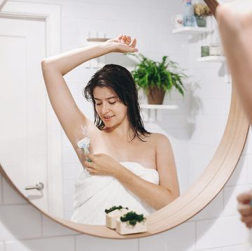 vrouw scheert in spiegel