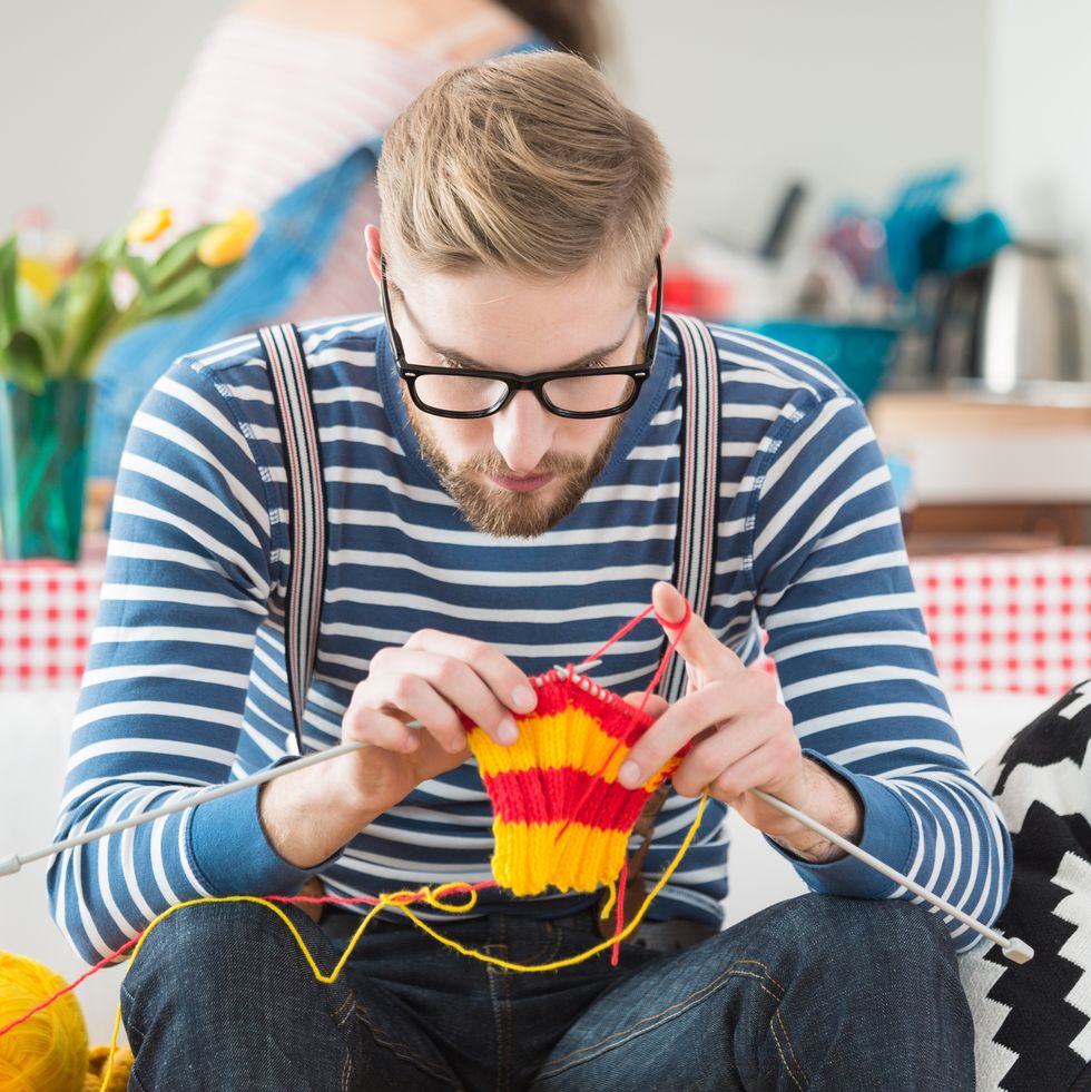 young bearded man knitting