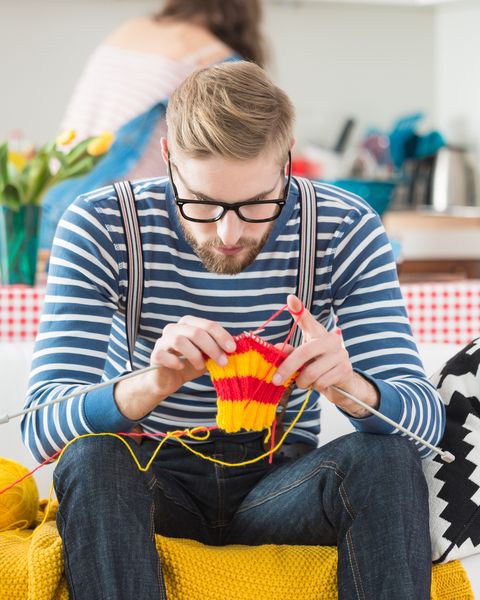 young bearded man knitting