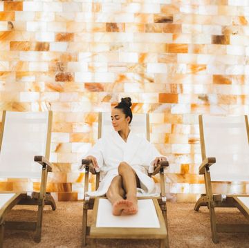 young beautiful woman in bathrobe relaxing in the salt room in spa centr.