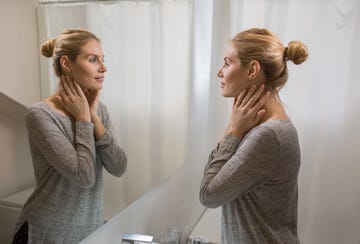 young beautiful woman looking herself in the mirror at bathroom