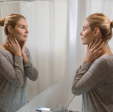 Young beautiful woman looking herself in the mirror at bathroom. young beautiful woman looking herself in the mirror at bathroom