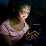 young woman texting on mobile phone at night