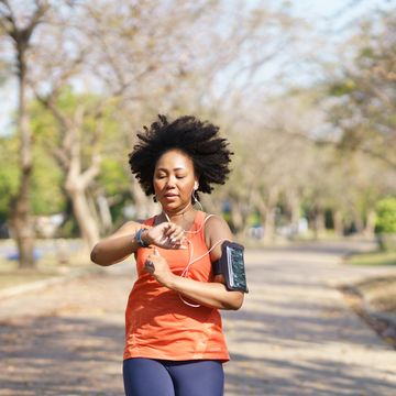 young black woman use fitness tracker on smartwatch tracking abilities heart rate, blood oxygen while running exercise at park