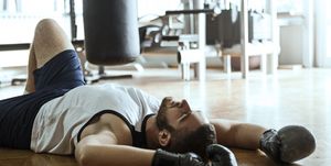 Young boxer resting after training lying on a floor