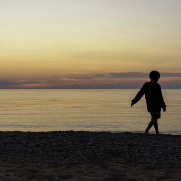 young boy at the beach at sunset