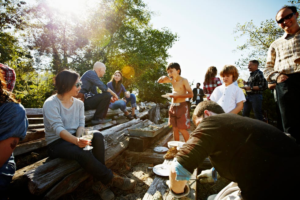 Young boy eating oyster with friends and family