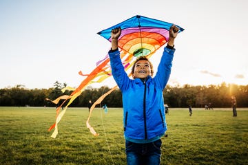 young boy enjoying learning how to fly kite