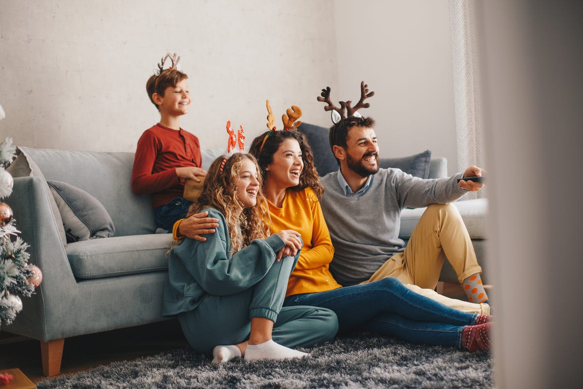 Happy young woman playing video game at home - a Royalty Free