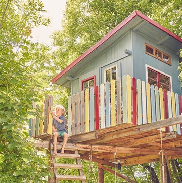 young boy painting tree house