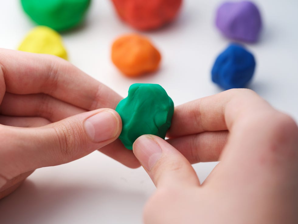 a young boy playing with play clay