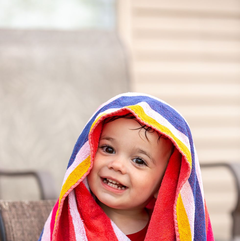 young boy wrapped in striped beach towel