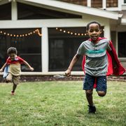 young boys in capes playing in backyard