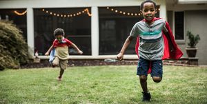 young boys in capes playing in backyard
