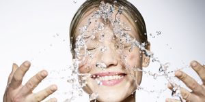 young caucasian female splashing her face