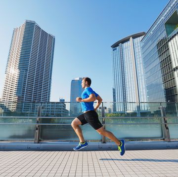 young caucasian man running in metropolitan area