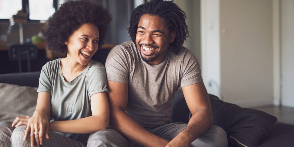 Joven y alegre pareja afroamericana en la sala de estar. joven y alegre pareja afroamericana en la sala de estar