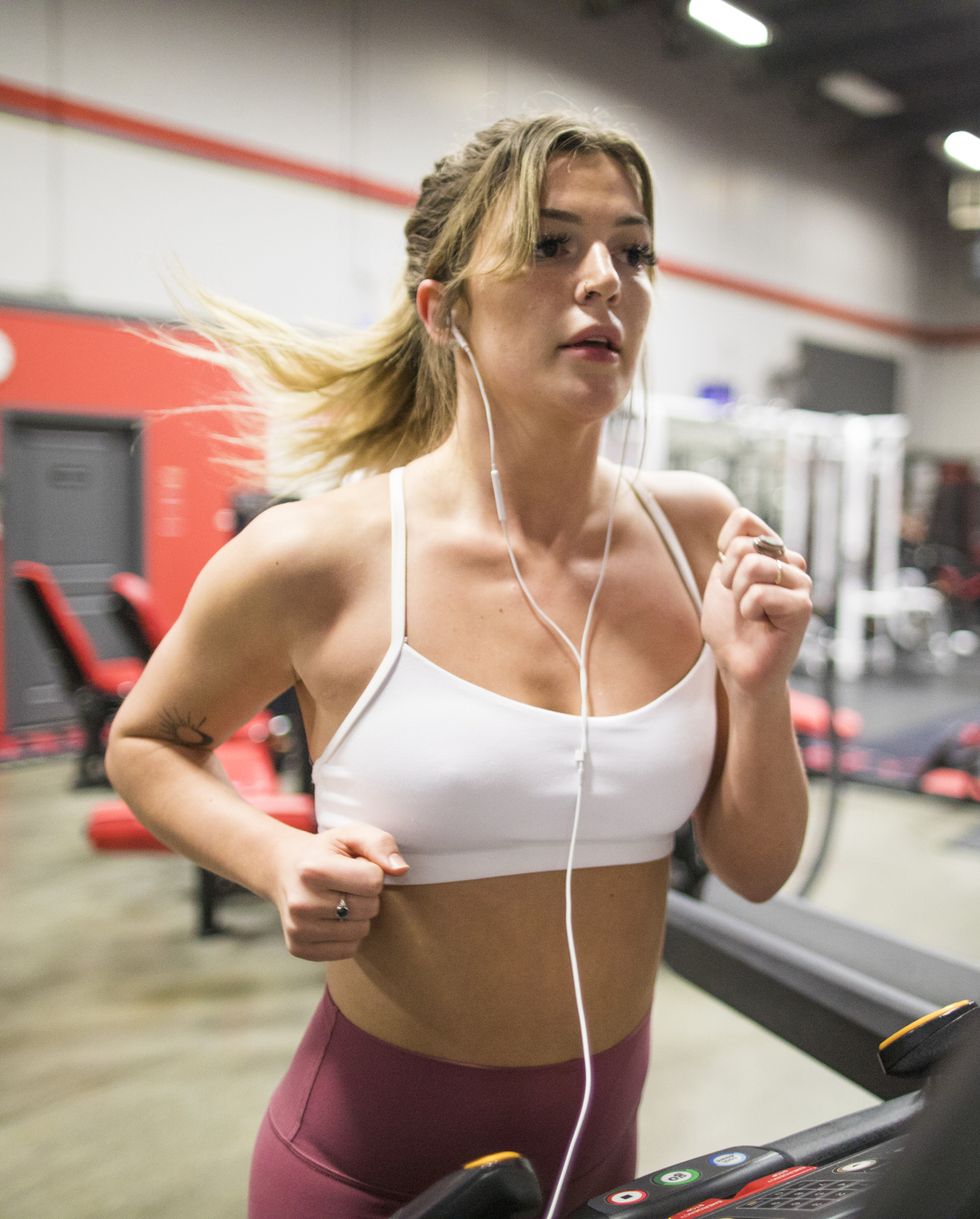 Young confident woman running on a treadmill