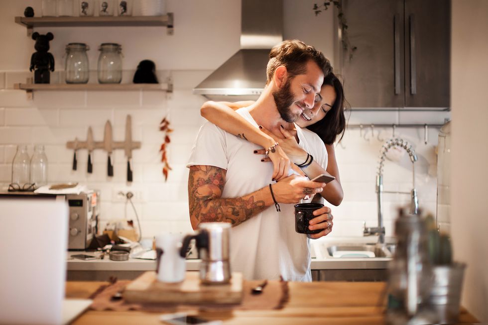 young couple at home using smartphone   morning breakfast time