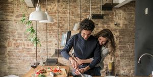 Young couple cooking fish cuisine at kitchen counter hob