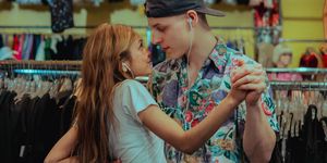 Young couple dancing in a thrift store while looking at each other