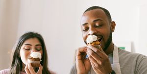 young couple having fun, eating fresh cupcakes