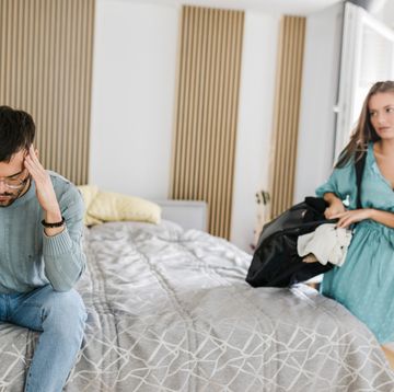 young couple having relationship difficulties, woman packing and leaving after fight