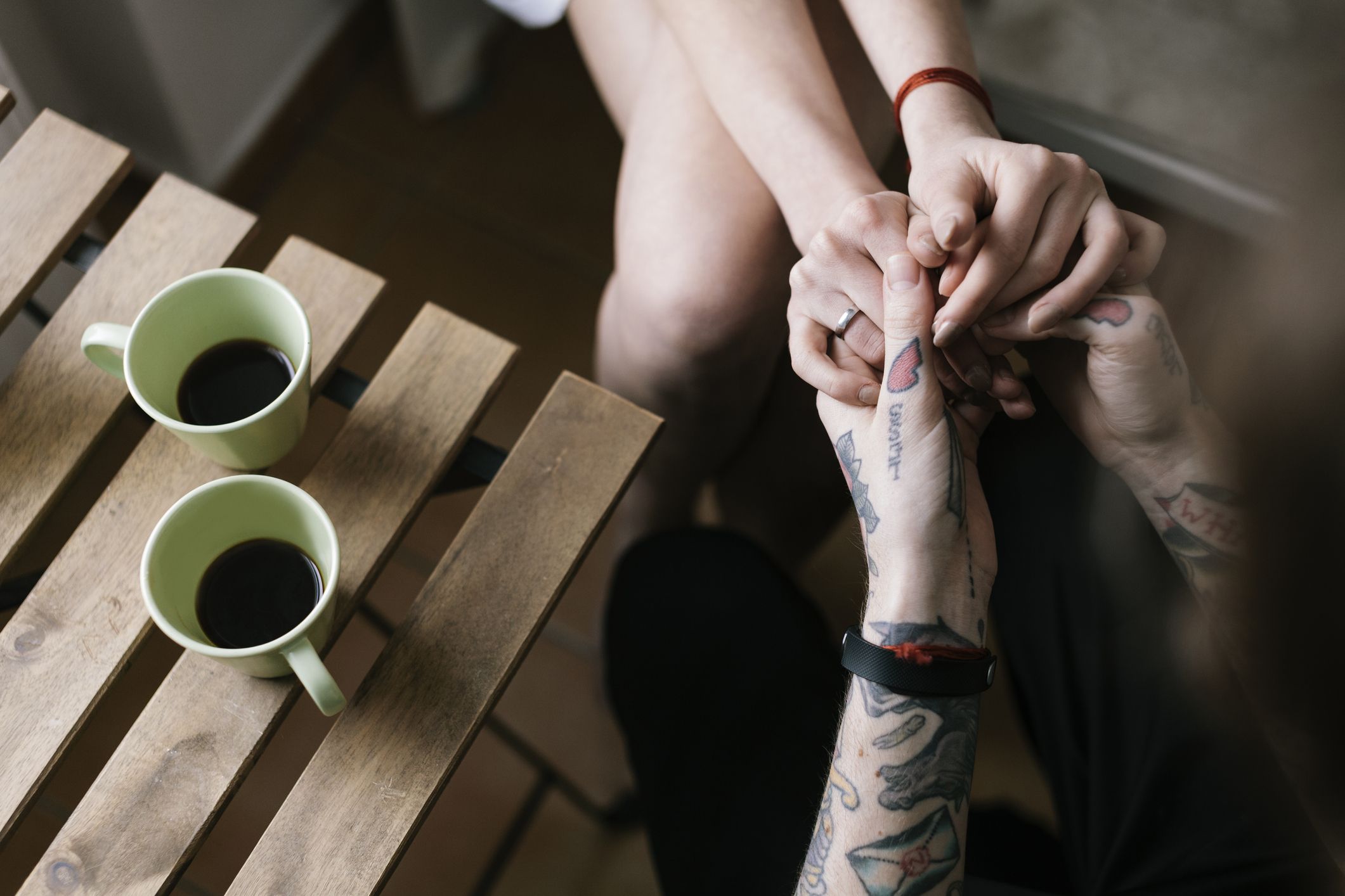 young couple holding hands at kitchen table