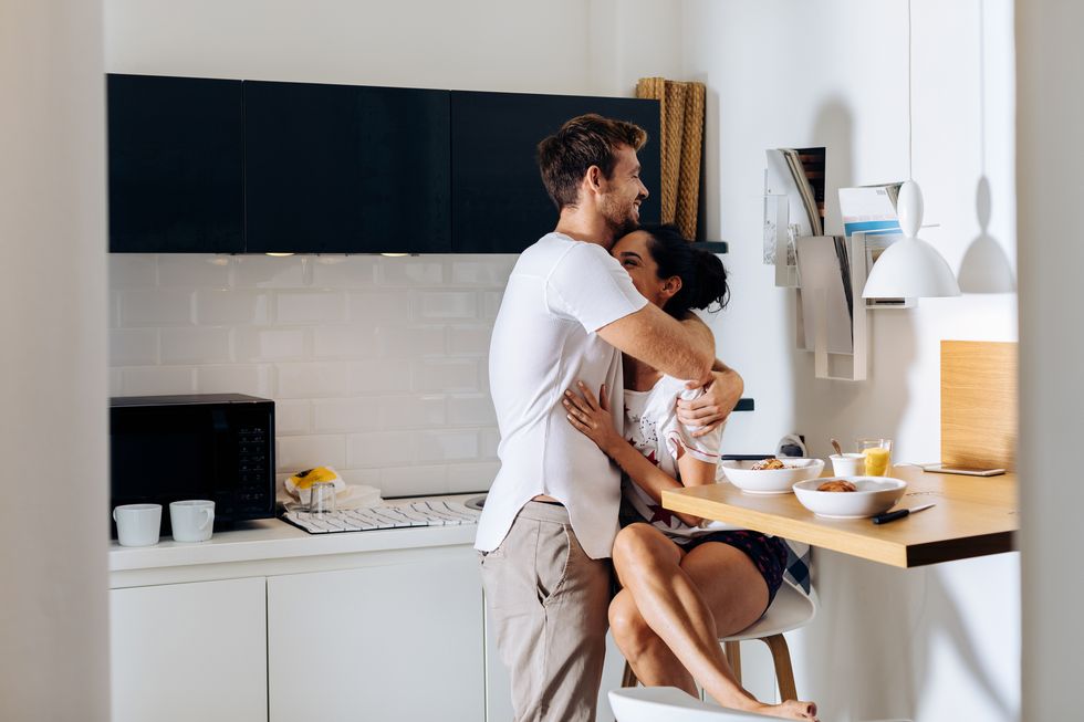 Young couple hugging in kitchen