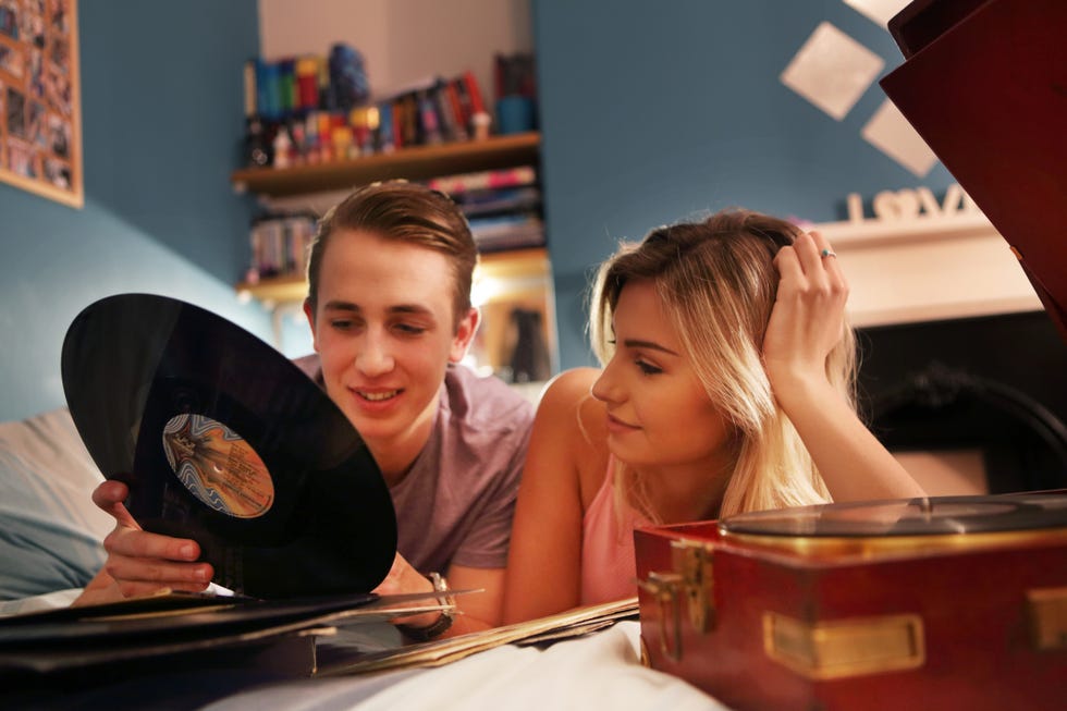 young couple in bedroom with record player