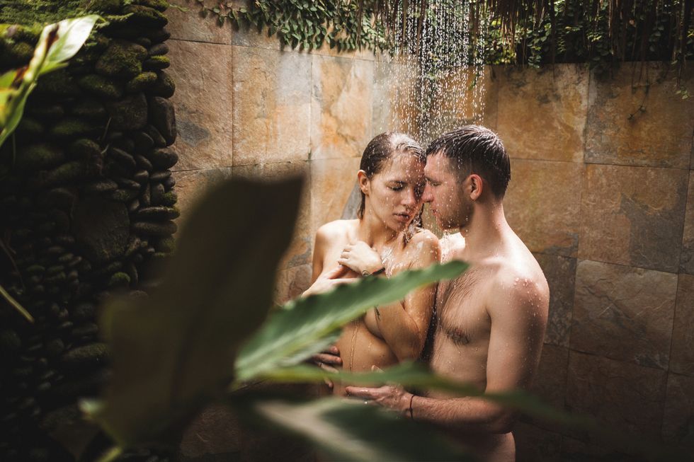 young couple in love kissing under tropical shower with passion intimate and romantic honeymoon in bali