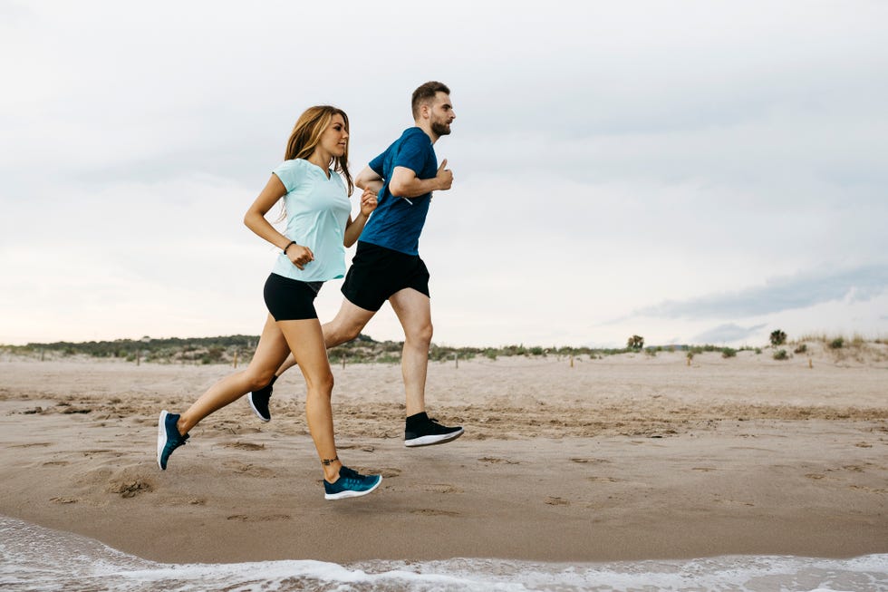 pareja corriendo por la playa