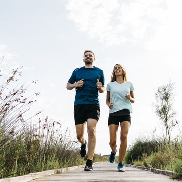 young couple jogging on wooden walkway