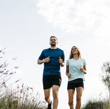 young couple jogging on wooden walkway