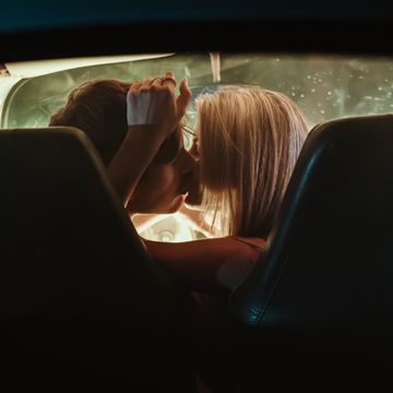 young couple kissing each other in car during date