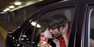 man en vrouw zoenen op de achterbank van een auto