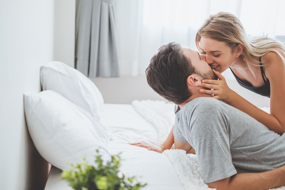 young couple kissing on bed