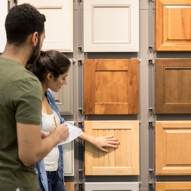 young couple look at cabinet samples in home improvement store