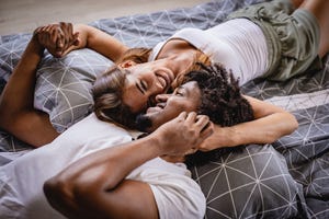young couple lying bed in bedroom and smiling