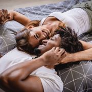 young couple lying bed in bedroom and smiling