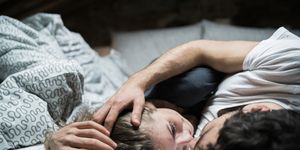 Young couple lying in bed embracing face to face