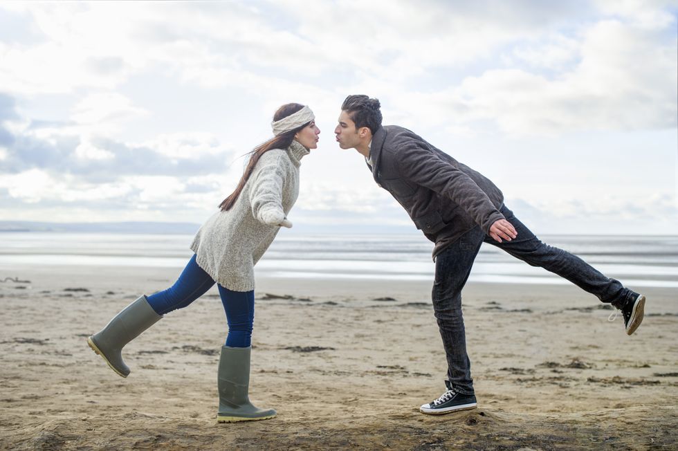 Young couple on one leg, Brean Sands, Somerset, England