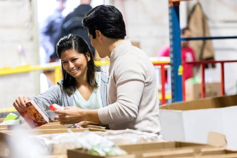 young couple pack up boxes for a food bank together