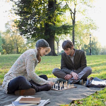Young couple playing chess in park young couple playing chess in park