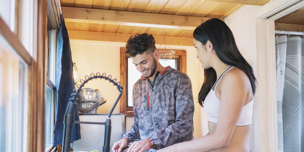 young couple preparing meal in kitchen of tiny house
