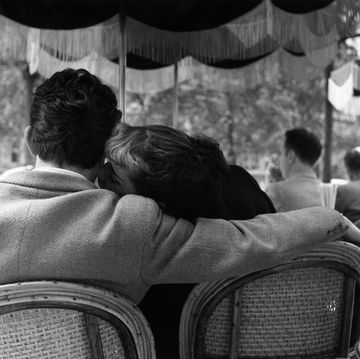 coppia si scambia un bacio seduti in un caffè parigino