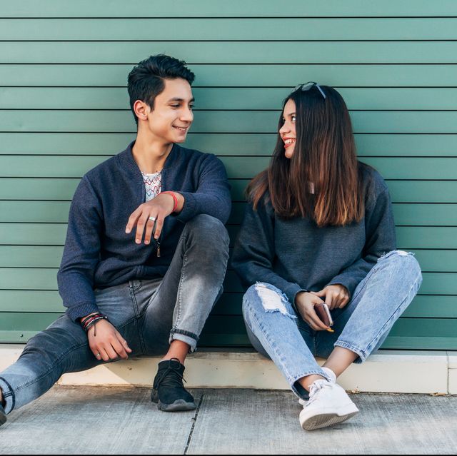 young couple sitting and looking into each other's eyes while chatting with smiling faces